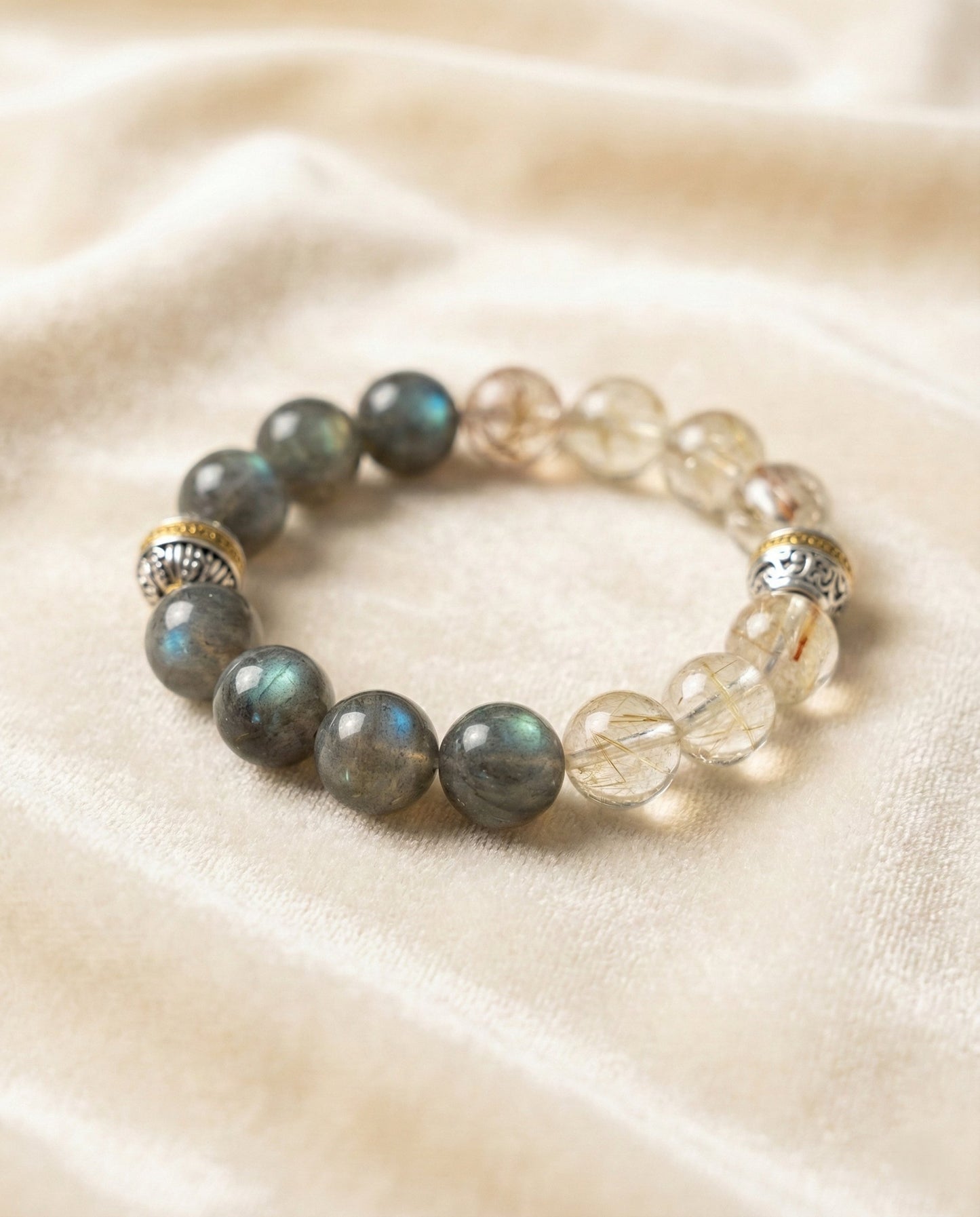 The Equilibrium Strand Bracelet, shown at a gentle angle on a light velvet surface.